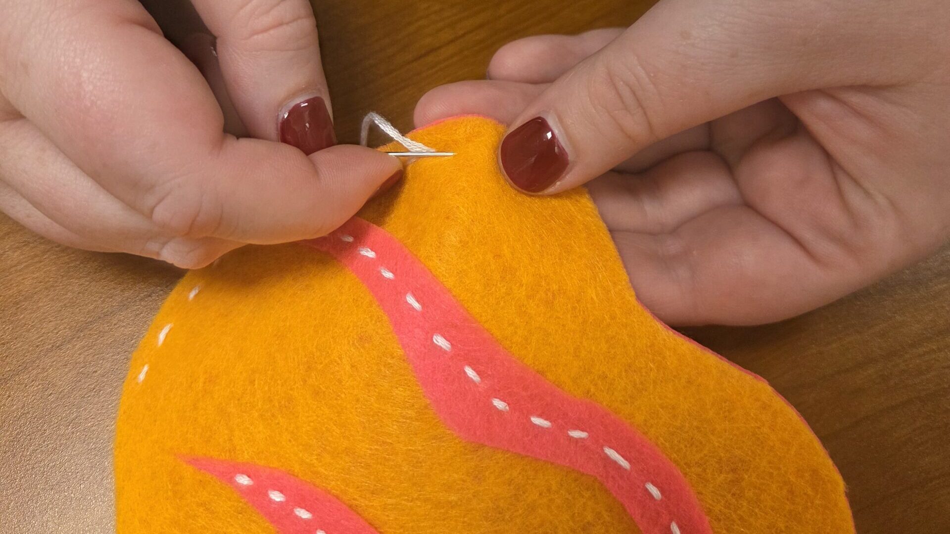 Sewing an orange and pink cushion